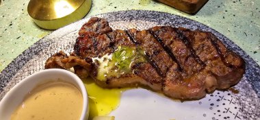 New York bifteği ya da patates ile servis edilen sığır filetosu ve mantar sosu ve tabak üzerinde salata.