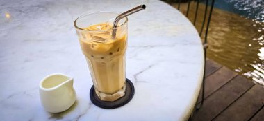 Fresh iced coffee in glass with frothy cream for your design, Food concept in style, copy space for content creation clipart