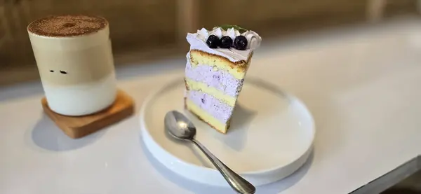 stock image slice of blueberry cake decorated with fresh berries on white plate, delicious layered cake, top view in the cafe