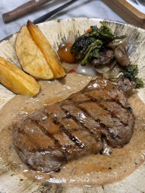 Fileto bifteği az pişmiş patates ve mantar soslu salata ile restoranda servis ediliyor.