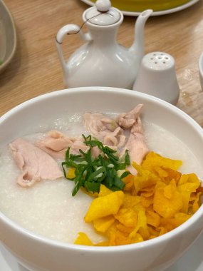 Öğütülmüş tavuklu pirinç lapası. Adı Bubur Ayam. Yanında kraker, dilimlenmiş taze soğan ve diğer soslarla birlikte restoranda servis ediliyor.