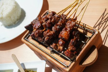 Baharat ve tatlı soya sosuyla marine edilmiş ev yapımı kuzu eti ya da koyun eti, kişniş keçisi satay, acılı, soya soslu ve domatesli servis ediliyor. Izgara et için Endonezya geleneksel satay tarifi