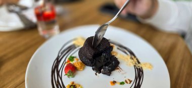 Lezzetli çikolata şekerlemesi ya da kremalı lav keki, çilekli ve kek bisküvisi, çikolatalı sıcak çikolata pudingi, yemek pişirme fikirleri ve tarifi için fondant au çikolatası.