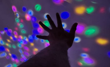 Renkli bir arkaplana uzanan el hareketi silueti, merhaba demek ve multimedya içeriği oluşturma için sayı göstermek