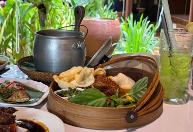 Sundan hindistancevizi pirinç paketi ya da eşsiz Sundan mutfağıyla Batı Java 'dan Nasi Liwet Sunda ngeliwet ya da botram adı verilen Sundan yemek geleneğinin farklı bir tadı ve sunumu kızarmış tavuk, sambal, satay, kraker, kızarmış 