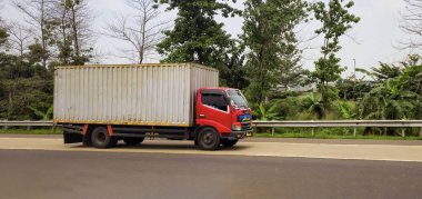 truck one of transportation mode making local commercial delivery at urban city and on the city streets in asia logistical transport system in Asian country Indonesia clipart