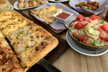 İnanılmaz ev yapımı İtalyan pizzası peynirli ve kıymalı sucuklu ayrıca ahşap masa pizzasında servis edilen sosisli, tam peynirli organik pizza sağlıklı yemek içeriği yaratmak için iyi.