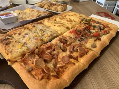 İnanılmaz ev yapımı İtalyan pizzası peynirli ve kıymalı sucuklu ayrıca ahşap masa pizzasında servis edilen sosisli, tam peynirli organik pizza sağlıklı yemek içeriği yaratmak için iyi.