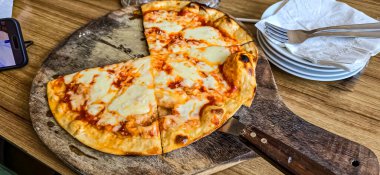 İnanılmaz ev yapımı İtalyan pizzası peynirli ve kıymalı sucuklu ayrıca ahşap masa pizzasında servis edilen sosisli, tam peynirli organik pizza sağlıklı yemek içeriği yaratmak için iyi.