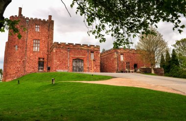 Kırsal Avrupa 'daki eski ve eski bir bina. Yeşil manzaraya ve mavi gökyüzüne dokunulmamış. Beyaz bulutlarla birlikte.