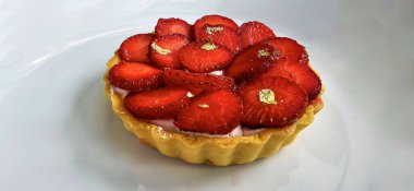 Lezzetli çilekli tart ya da çilekli tart ve yenilebilir altın taneleriyle süslenmiş krema. Multimedya tarifi içeriği yaratmak için iyi.