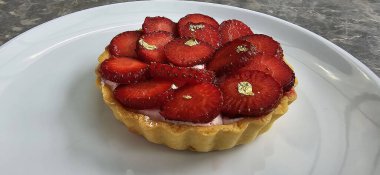 Lezzetli çilekli tart ya da çilekli tart ve yenilebilir altın taneleriyle süslenmiş krema. Multimedya tarifi içeriği yaratmak için iyi.