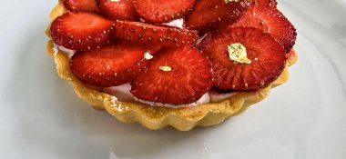 Lezzetli çilekli tart ya da çilekli tart ve yenilebilir altın taneleriyle süslenmiş krema. Multimedya tarifi içeriği yaratmak için iyi.
