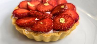 Lezzetli çilekli tart ya da çilekli tart ve yenilebilir altın taneleriyle süslenmiş krema. Multimedya tarifi içeriği yaratmak için iyi.