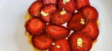 Lezzetli çilekli tart ya da çilekli tart ve yenilebilir altın taneleriyle süslenmiş krema. Multimedya tarifi içeriği yaratmak için iyi.