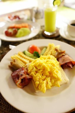 Asyalı stili bir otelde havuzun yanında kahvaltı. Güneşli yaz günlerinde tatil köyündeki güzel mavi havuz kenarında nefis yiyeceklerle dolu bir masa. Dinlenme ve tatil lüks otel, tatil