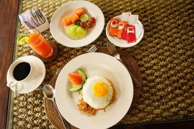 Asyalı stili bir otelde havuzun yanında kahvaltı. Güneşli yaz günlerinde tatil köyündeki güzel mavi havuz kenarında nefis yiyeceklerle dolu bir masa. Dinlenme ve tatil lüks otel, tatil