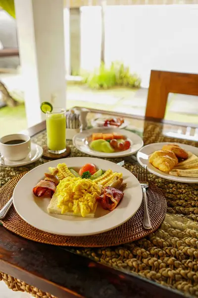 Breakfast at hotel style at Asian style hotel by the swimming pool. Table with delicious food by the beautiful blue pool travel in resort on sunny summer day. Rest and vacation in luxury hotel, holiday