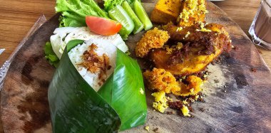 Kızarmış ve ızgara tavuklu pilav, Nasi kampüsü adı verilen geleneksel Endonezya mutfağı yerel salata, acı biber ezmesi ve kraker ile servis edilen kızarmış ya da ızgara tavuktan oluşur.