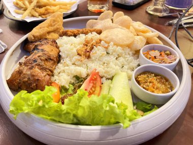 Kızarmış ve ızgara tavuklu pilav, Nasi kampüsü adı verilen geleneksel Endonezya mutfağı yerel salata, acı biber ezmesi ve kraker ile servis edilen kızarmış ya da ızgara tavuktan oluşur.