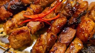 Baharat ve tatlı soya sosuyla marine edilmiş ev yapımı sığır eti, kişniş bifteği satay, soğan, biber, soya sosu ve domates ile servis edilen tabakta. Endonezya geleneksel yemekleri