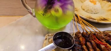 Baharat ve tatlı soya sosuyla marine edilmiş ev yapımı sığır eti, kişniş bifteği satay, soğan, biber, soya sosu ve domates ile servis edilen tabakta. Endonezya geleneksel yemekleri