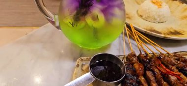 Baharat ve tatlı soya sosuyla marine edilmiş ev yapımı sığır eti, kişniş bifteği satay, soğan, biber, soya sosu ve domates ile servis edilen tabakta. Endonezya geleneksel yemekleri