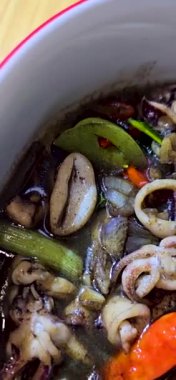 Tumis Cumi Hitam adında baharatlı siyah mürekkep soslu sotelenmiş mürekkep balığı, Chili, zencefil ve limon yaprağı da dahil olmak üzere Endonezya ev yapımı yemek menüsü.