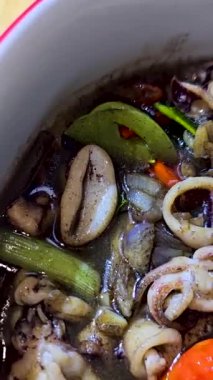 Tumis Cumi Hitam adında baharatlı siyah mürekkep soslu sotelenmiş mürekkep balığı, Chili, zencefil ve limon yaprağı da dahil olmak üzere Endonezya ev yapımı yemek menüsü.
