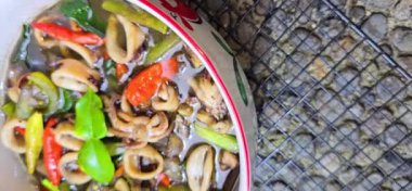 Tumis Cumi Hitam adında baharatlı siyah mürekkep soslu sotelenmiş mürekkep balığı, Chili, zencefil ve limon yaprağı da dahil olmak üzere Endonezya ev yapımı yemek menüsü.