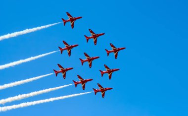 Kırmızı oklar İngiltere 'de mavi gökyüzünde manevra yapıyor. Uçak jeti Cosford United Kindom' daki bir hava gösterisinde akrobatik ve uçan formasyonlar yapıyor.