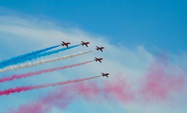 Kırmızı oklar İngiltere 'de mavi gökyüzünde manevra yapıyor. Uçak jeti Cosford United Kindom' daki bir hava gösterisinde akrobatik ve uçan formasyonlar yapıyor.