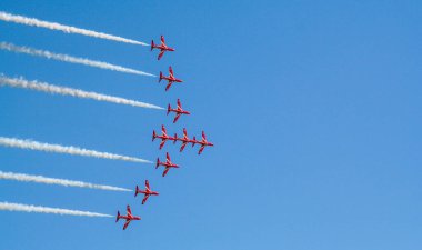 Kırmızı oklar İngiltere 'de mavi gökyüzünde manevra yapıyor. Uçak jeti Cosford United Kindom' daki bir hava gösterisinde akrobatik ve uçan formasyonlar yapıyor.