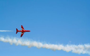 Kırmızı oklar İngiltere 'de mavi gökyüzünde manevra yapıyor. Uçak jeti Cosford United Kindom' daki bir hava gösterisinde akrobatik ve uçan formasyonlar yapıyor.