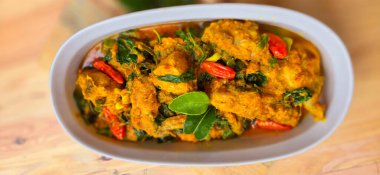 spicy sauteed herb chicken called ayam woku Manado, Woku is a Manadonese spice dish from North Sulawesi province , Indonesia , made from various spices and commonly used for cooking meat spiced chicken on a white plate. Perfect for recipe, article, c clipart