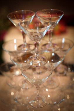 Şatafatlı bir parti atmosferinde bir bardak şampanya ya da şarap bardağı. Tost ve kutlama için, şık, renkli fotoğraf, laik resepsiyon, yeni yıl, düğün, ışıl ışıl şampanya bardakları konsepti