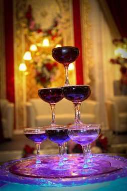 Şatafatlı bir parti atmosferinde bir bardak şampanya ya da şarap bardağı. Tost ve kutlama için, şık, renkli fotoğraf, laik resepsiyon, yeni yıl, düğün, ışıl ışıl şampanya bardakları konsepti