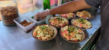 Bubur ayam adında doğranmış tavuklu pirinç lapası, kraker ve taze soğanla servis edilir ve diğer baharatlar Endonezya sokak yemeklerinden biri, yemek tarifi kitabı için iyidir.