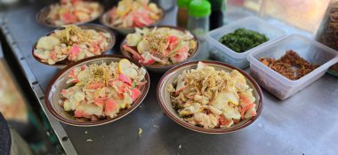 Bubur ayam adında doğranmış tavuklu pirinç lapası, kraker ve taze soğanla servis edilir ve diğer baharatlar Endonezya sokak yemeklerinden biri, yemek tarifi kitabı için iyidir.