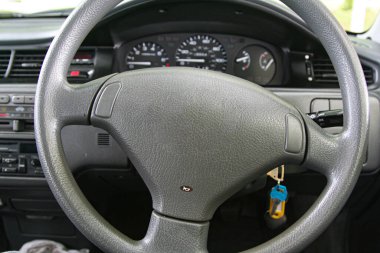 Bir arabanın direksiyon simidinin ayrıntılı görüntüsü gösterge paneli enstrümanlarıyla açıkça görülüyor, sürüş, kontrol ve otomotiv tasarımı temaları çağrıştırıyor. Araba içeriği için iyi.