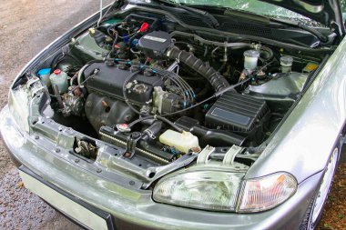 Kaputu açık, motoru ve çeşitli mekanik parçaları olan bir arabanın görüntüsü. Otomotiv ve mekanik temalar için ideal teknoloji, tamir ve mühendislik kavramları. Araba kataloğu için iyi