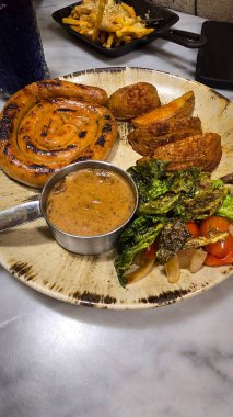 Ağız sulandıran Almanların en kötü kıvrımlı sosisi ızgara sosis, patates kızartması ve köy tabağında servis edilen taze sebzeler. Akşam yemeği aşıkları için mükemmel. Yürekli ve lezzetli yemekleri takdir ederler..