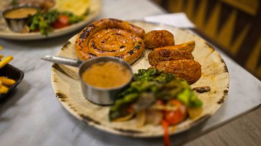 Ağız sulandıran Almanların en kötü kıvrımlı sosisi ızgara sosis, patates kızartması ve köy tabağında servis edilen taze sebzeler. Akşam yemeği aşıkları için mükemmel. Yürekli ve lezzetli yemekleri takdir ederler..