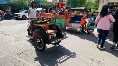 pedicab or rickshaw or locals calls it becak with a canopy is parked on a sunny street, reflecting a vibrant urban scene. The vehicle features a padded seat and unique design, typical in Southeast Asia. clipart