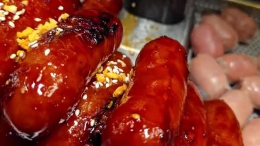 Lezzetli, parlak renkli sosisler Tayland 'daki bir yemek festivalinde gösterişli bir şekilde istiflenmiş. Mutfak zevkini ve hoşgörüyü çağrıştırıyor..