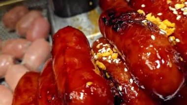 Lezzetli, parlak renkli sosisler Tayland 'daki bir yemek festivalinde gösterişli bir şekilde istiflenmiş. Mutfak zevkini ve hoşgörüyü çağrıştırıyor..