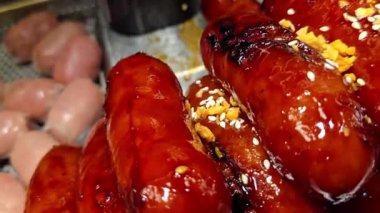 Lezzetli, parlak renkli sosisler Tayland 'daki bir yemek festivalinde gösterişli bir şekilde istiflenmiş. Mutfak zevkini ve hoşgörüyü çağrıştırıyor..