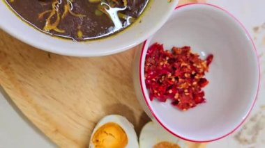 Rawon çorbası ya da Endonezya siyah et çorbası, siyah renk Endonezya fındığı Kluwek 'ten. Limon, biber ezmesi, tuzlu yumurta ve krakerle servis edilir. Yemek tarifi, makale veya herhangi bir yemek içeriği veya blog için mükemmel