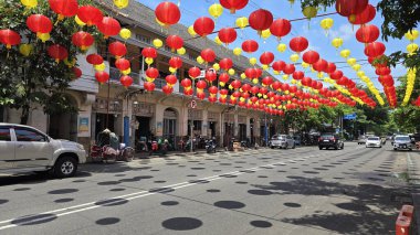 Canlı kırmızı ve sarı fenerler, Çin 'in yeni yılını ve geleneksel kültür dekoru kutlamalarını temsil eden huzurlu mavi gökyüzünün altında açık balkonlarda asılı duruyor. arkaplan için iyi
