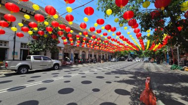Canlı kırmızı ve sarı fenerler, Çin 'in yeni yılını ve geleneksel kültür dekoru kutlamalarını temsil eden huzurlu mavi gökyüzünün altında açık balkonlarda asılı duruyor. arkaplan için iyi